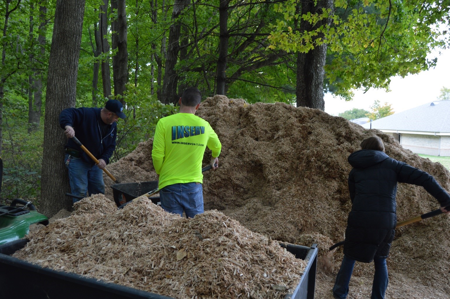 bulk mulch pile with inserv employees moving