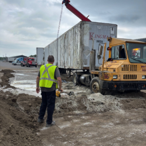 Emergency Spill Services A site operator monitoring a crane rigging setup on a semi-trailer and terminal tractor during a recovery operation.