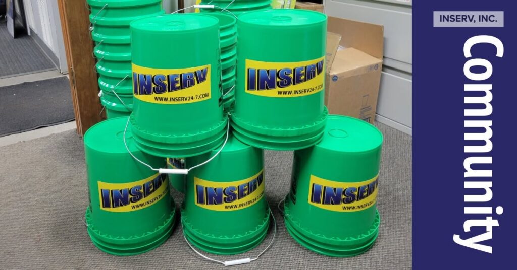 The image features five green buckets stacked on top of each other with the INSERV logo. There are other buckets in the background. There is a banner that says "community" along the right side.